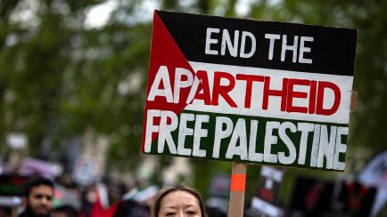 Una manifestante sostiene un cartel denunciando en "apartheid" de Israel y defendiendo la libertad de los palestinos en una marcha en Londres, el pasado 22 de abril. 