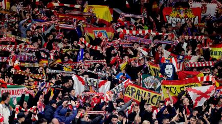 Aficionados del Atlético de Madrid muestran banderas durante un partido europeo contra el Manchester United en el estadio de Old Trafford.