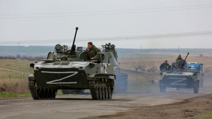 FILE - Russian military vehicles move on a highway in an area controlled by Russian-backed separatist forces near Mariupol, Ukraine, April 18, 2022. Mariupol, a strategic port on the Sea of Azov, has been besieged by Russian troops and separatis...