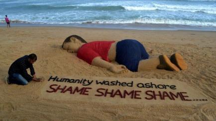 El artista indio Sudarsan Pattnaik trabaja en una escultura de arena del pequeño Aylan Kurdi, el niño sirio de 3 años que fue encontrado muerto en una playa de Turquía, en Puri (India) el 4 de septiembre de 2015