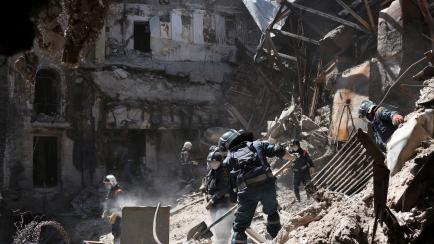 Operarios del Ministerio de Situaciones de Emergencia de la República Popular de Donetsk retiran escombros en un teatro de Mariúpol dañado por los intensos combates por la ciudad, en territorio controlado por la República Popular de Donetsk,...