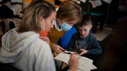 Carme, a resident from Catalonia, teaches Catalan language to Tetiana Horobii and her son Maxym Batrak in the village of Guissona, Lleida, Spain, Tuesday, March 22, 2022. Long before Russian tanks rolled into Ukraine, the tiny town of Guissona w...