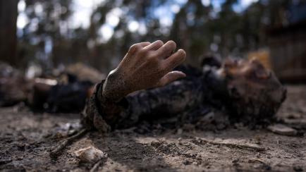The charred body of a man along with five other people, lie on the ground in Bucha, on the outskirts of Kyiv, Ukraine, Monday, April 4, 2022. Russia is facing a fresh wave of condemnation after evidence emerged of what appeared to be deliberate ...