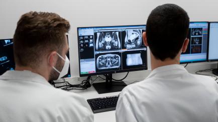 Dos profesionales sanitarios observan un equipo de radioterapia en el Hospital La Paz de Madrid.