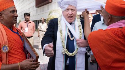 GANDHINAGAR, INDIA - APRIL 21: UK prime minister Boris Johnson having a turban placed on his head at Gujarat Bio Technology University, during his two day trip to India on April 21, 2022 in Gandhinagar, India. During his two-day visit to India B...