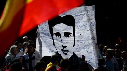 People display a portrait of Basque Popular Party councillor and victim of ETA Miguel Angel Blanco as they gather with thousands of Spaniards at Plaza de Colon to answer a call by Association of Victims of Terrorism (AVT) to protest against a Eu...