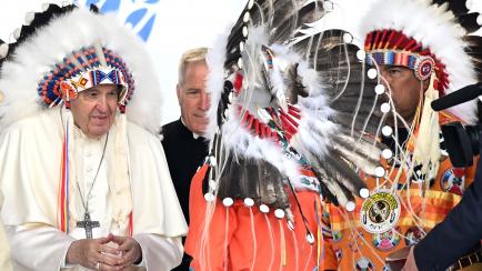 El papa luce parte de la vestimenta indígena que le ofrecen varios líderes nativos en Maskwacis (Canada)