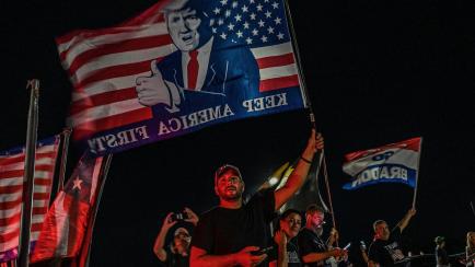 Supporters of former US President Donald Trump stand outside his residence in Mar-A-Lago, Palm Beach, Florida on August 8, 2022. - Former US president Donald Trump said August 8, 2022 that his Mar-A-Lago residence in Florida was being "raided" b...