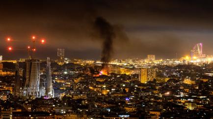 In this Friday, Oct. 18, 2019 photo, smoke caused by fires set by pro-independence demonstrators rises over Barcelona, Spain. The mayor of riot-stricken Barcelona has called for calm after violent protests by Catalan separatists rocked Spain's s...