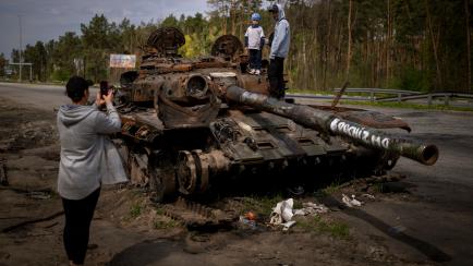 Unos niños ucranianos se fotografían sobre un tanque ruso reventado en las afueras de Kiev, el pasado mayo. 