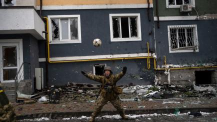 Ukranian soldiers play with a ball in Irpin, on the outskirts of Kyiv, Ukraine, Saturday, April 2, 2022. (AP Photo/Rodrigo Abd)