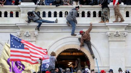 Varios de los asaltantes del Capitolio, escalando por la fachada, el pasado 6 de enero.