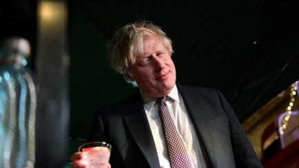 Britain's Prime Minister Boris Johnson samples an Isle of Harris Gin as he visits a UK Food and Drinks market set up in Downing Street, central London on November 30, 2021. (Photo by JUSTIN TALLIS / various sources / AFP) (Photo by JUSTIN TALLIS...