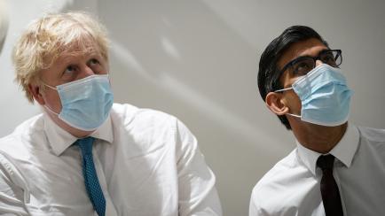 British Prime Minister Boris Johnson (L) and Britain's Chancellor of the Exchequer Rishi Sunak (R) react as they attend a visit of the Kent Oncology Centre at Maidstone Hospital, in Maidstone, on February 7, 2022, as part of a tour in Kent. (Pho...