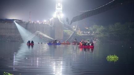 Equipos de rescate rastrean el río en busca de desaparecidos tras la caída del puente en India. 