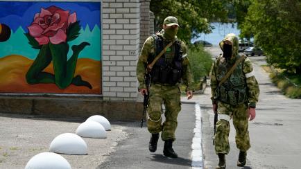 FILE - Two Russian soldiers patrol an administrative area at the Khersonvodokanal (water channel) in Kherson, Kherson region, south Ukraine, on May 20, 2022. In the southern city of Kherson, one of the first seized by Russia and a key target of ...