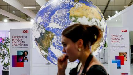 A participant walks past a mockup of the planet Earth globe at the Sharm el-Sheikh International Convention Centre, on the first day of the COP27 climate summit, in Egypt's Red Sea resort city of Sharm el-Sheikh, on November 6, 2022. (Photo by M...