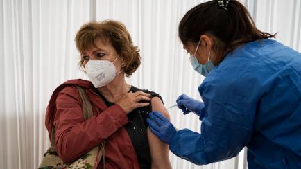 A nurse administers the AstraZeneca vaccine against Covid-19 to a woman at Casal de Gent Gran Quatre Cantons in Barcelona, Spain, on April 15, 2021. (Photo by Pau de la Calle/NurPhoto via Getty Images)