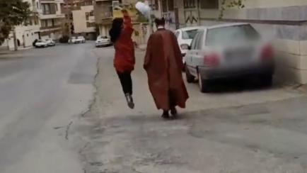 Una joven iraní quita el turbante a un clérigo.