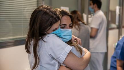 Dos sanitarias se abrazan en la Unidad de Cuidados Intensivos en el Hospital Clinic de Barcelona.