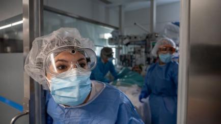 Una sanitaria se prepara para atender a un paciente con covid en un hospital de Barcelona