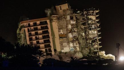 The rest of the Champlain South tower is demolished with a controlled explosion in Surfside, Florida, north of Miami Beach, late on July 4, 2021. - A controlled explosion brought down the unstable remains of the collapsed apartment block in Flor...
