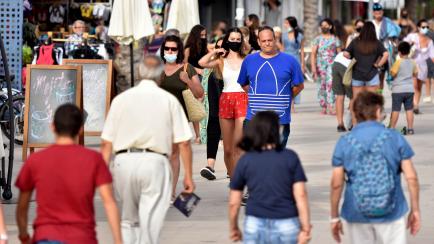 VENDRELL, TARRAGONA, SPAIN - 2021/07/11: People with face masks and others without face masks walk along Paseo Maritimo Street in Vendrell.
Since last June 26, in Spain it is no longer mandatory to use a facial mask to avoid contagion of Covi-19...