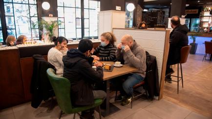 People wearing face masks sit inside a restaurant in the northern Spanish Basque city of San Sebastian on February 10, 2021 after the  Basque Country High Court of Justice lifted coronavirus restrictions in bars and restaurants. (Photo by ANDER ...
