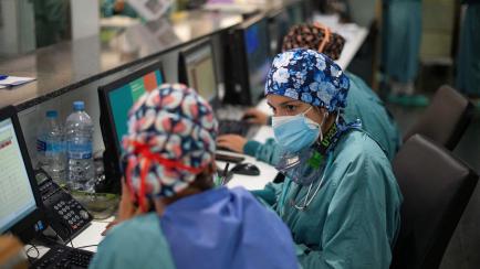 Healthcare workers discuss about a Covid-19 patient at the Intensive Care Unit (ICU) of the Hospital del Mar in Barcelona on August 4, 2021. - Catalonia has Spain's highest Covid-19 incidence rate. The surge in new infections has put pressure on...