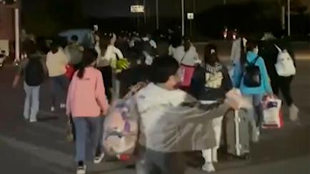 FILE - In this photo taken from video footage and released by Hangpai Xingyang, people with suitcases and bags are seen leaving from a Foxconn compound in Zhengzhou in central China's Henan Province on Oct. 29, 2022. Employees at the world's big...