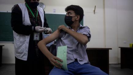 A Palestinian high school student receives a shot of the Pfizer coronavirus vaccine at a school in Gaza City, Wednesday, Sept. 1, 2021. Palestinian health authorities are launching a vaccination drive for students aged 16-18 in the Gaza Strip as...