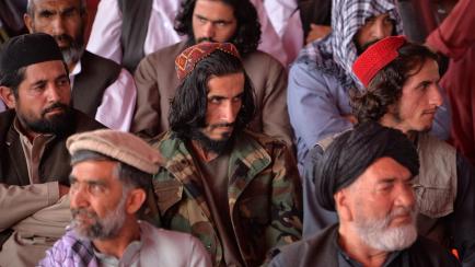 People attend an open-air rally in a field on the outskirts of Kabul on October 3, 2021, as the Taliban supporters and senior figures held their first mass rally in a show of strength as they consolidate their rule of Afghanistan. (Photo by Hosh...
