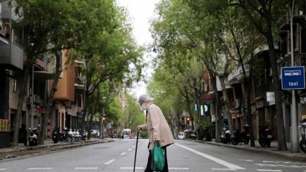 Mujer de avanzada edad cruzando una calle española.