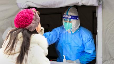 HOHHOT, CHINA - NOVEMBER 29, 2022 - A medical worker carries out nucleic acid sampling for residents at a residential complex in Hohhot, Inner Mongolia, China, Nov 29, 2022. (Photo credit should read CFOTO/Future Publishing via Getty Images)