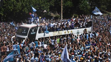 Argentina's players celebrate on board a bus with a sign reading "World Champions" with supporters after winning the Qatar 2022 World Cup tournament as they tour through Buenos Aires' downtown on December 20, 2022. - Millions of ecstatic fans ar...