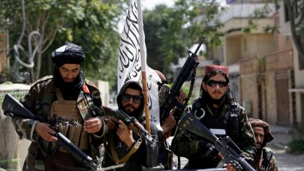 Taliban fighters display their flag on patrol in Kabul, Afghanistan, Thursday, Aug. 19, 2021. The Taliban celebrated Afghanistan's Independence Day on Thursday by declaring they beat the United States, but challenges to their rule ranging from r...