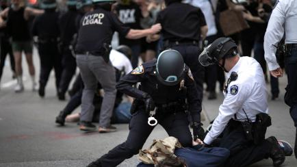 Police arrest a protester refusing to get off the streets during an imposed curfew while marching in a solidarity rally calling for justice over the death of George Floyd Tuesday, June 2, 2020, in New York. Floyd died after being restrained by M...