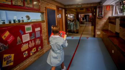 BOADILLA DEL MONTE, SPAIN - SEPTEMBER 06: A student carries books down a hallway during the first day of classes of the 2021-22 school year at the Virgen de Europa school on September 6, 2021 in Boadilla del Monte, Spain. The third school year a...