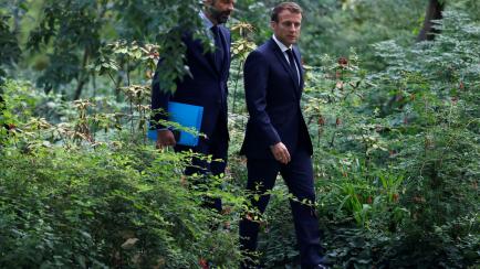 TOPSHOT - French President Emmanuel Macron (R) and French Prime Minister Edouard Philippe arrive for a meeting with members of the Citizens' Convention on Climate (CCC) to discuss over environment proposals at the Elysee Palace in Paris on June ...