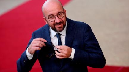 European Council President Charles Michel removes his protective face mask as he prepares to make a statement prior to a round table meeting at an EU summit in Brussels on July 20, 2020, as the leaders of the European Union hold their first face...