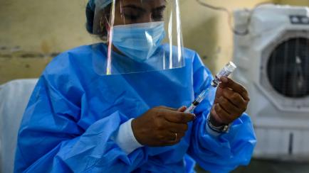 Una trabajadora prepara una inyección de la vacuna anticovid de AstraZeneca en Nueva Delhi (India).