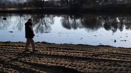 TURIN, ITALY - FEBRUARY 08: Man walks on dry land of river of La Stura di Lanzo river in dry phase caused by drought due to climate change on February 08, 2022 in Turin, Italy. Some 50 days have passed without rain in the northern Italian region...