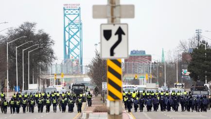 Police walk the line to remove all truckers and supporters after a court injunction gave police the power to enforce the law after protesters blocked the access leading from the Ambassador Bridge, linking Detroit and Windsor, as truckers and the...