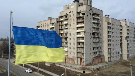 AVDIIKA, UKRAINE - FEBRUARY 17: A flag of Ukraine flies in front of a building, damaged in the clashes between Ukrainian army and pro-Russian separatists, is seen as diplomatic efforts to resolve the Ukraine-Russia crisis continue on February 17...