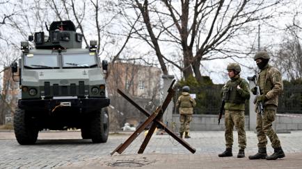Ukrainian Military Forces servicemen block a road in the so-called government quarter in Kyiv on February 24, 2022 as Russia's ground forces invaded Ukraine from several directions today, encircling the country within hours of Russian President ...
