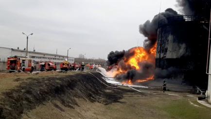 Bomberos rusos tratan de apagar el incendio en un depósito de combustible bombardeado por Ucrania en Bélgorod (Rusia).