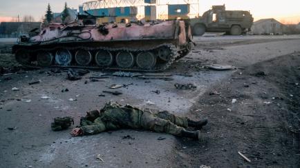 El cuerpo de un soldado sin insignias, posiblemente ruso, yace junto a un tanque destrozado en una carretera a las afueras de Jarkov, el primer día de la invasión rusa, 24 de febrero de 2022. 