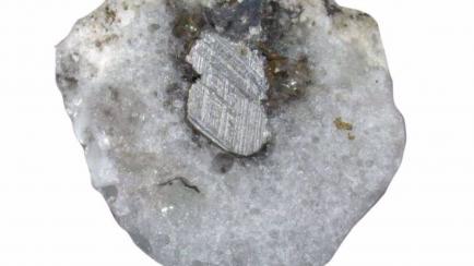 Sección transversal de una muestra de fulgurita que presenta arena fundida y metal conductor fundido de un tendido eléctrico caí­do.  