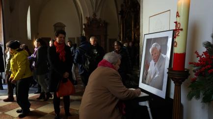Católicos en la catedral de Frisinga rezan delante de un retrato de Benedicto XVI