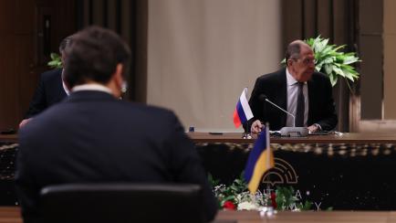 Sergey Lavrov (al fondo) y Dimitro Kuleba (de espaldas), ministros de Exteriores ruso y ucraniano, en su reunión en Turquía el 10 de marzo